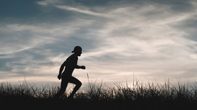 Silhouette of a man running through a field
