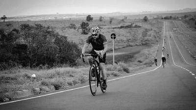 Triathlete cycling on a long road.